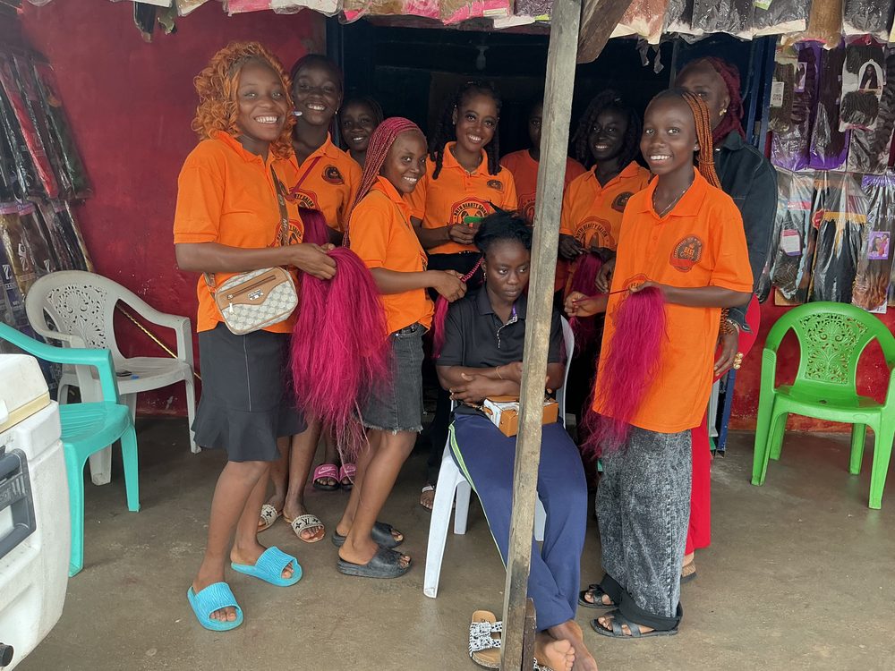 Face of Beauty trainees in orange uniforms at Ruth Beauty Salon